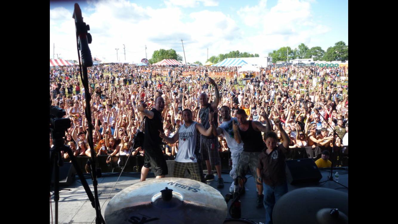 Festival crowd seen from stage level with performers and guests in front of a large audience