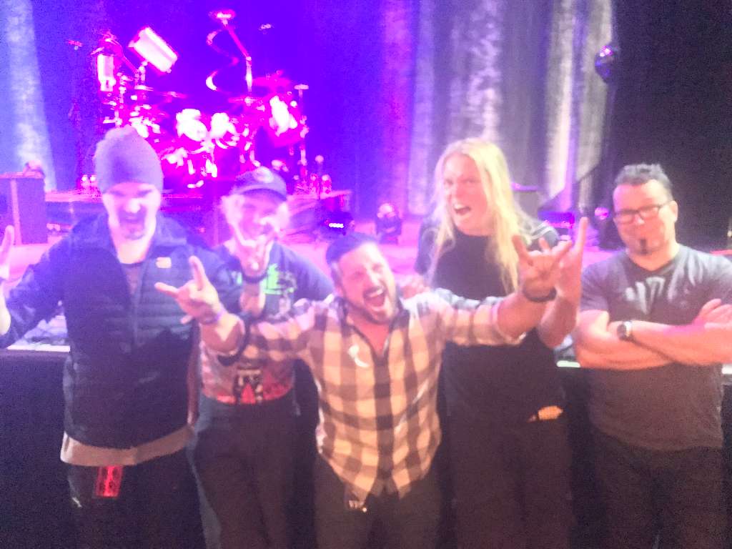 Live music and performance photo with artists, crew, and event guests.