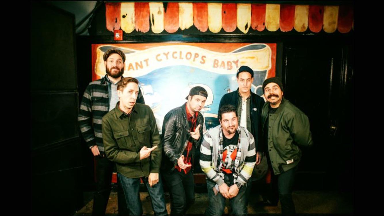 Live music and performance photo with artists, crew, and event guests.