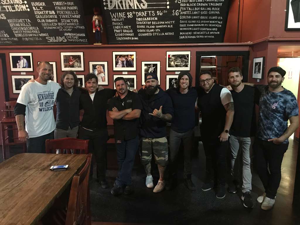 Live music and performance photo with artists, crew, and event guests.